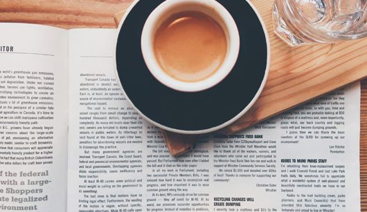 coffee cup on top of newspaper ads