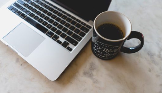 coffee cup next to laptop