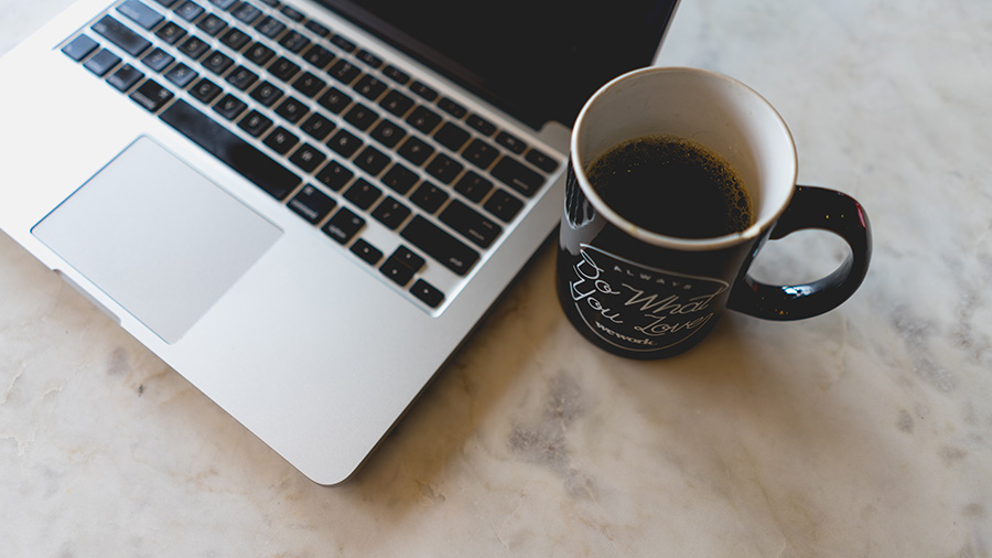 coffee cup next to laptop