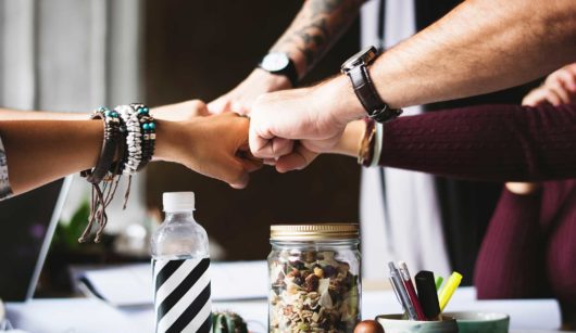 team of employees fist bumping