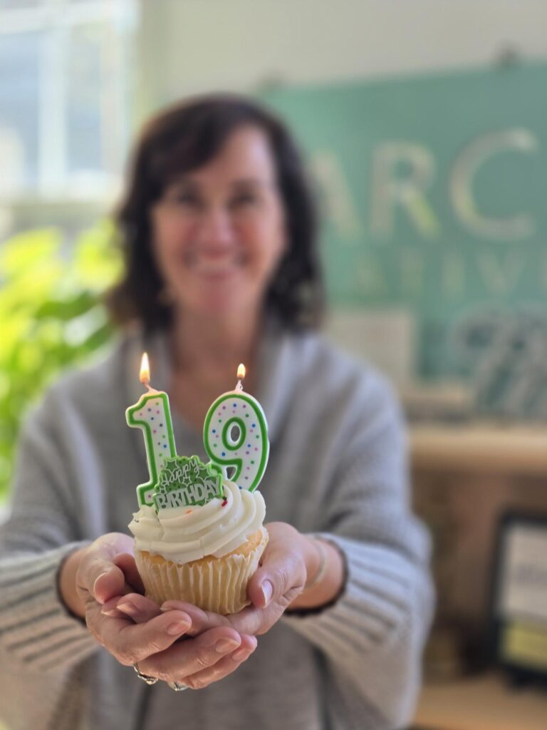 Woman holding cupcake with candles that say 19